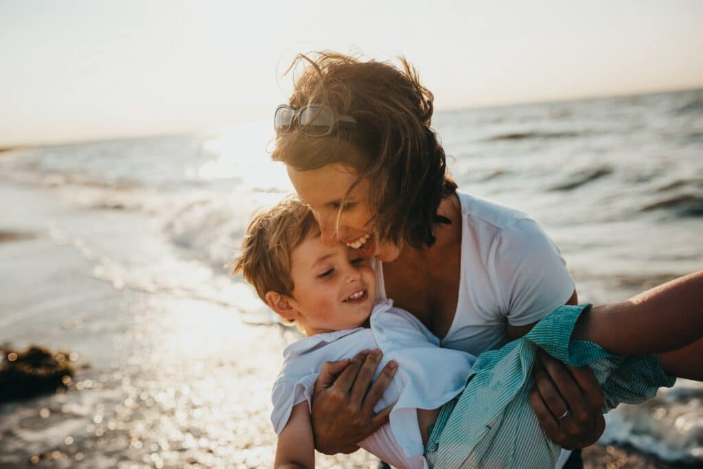 Mother holding child at beach
