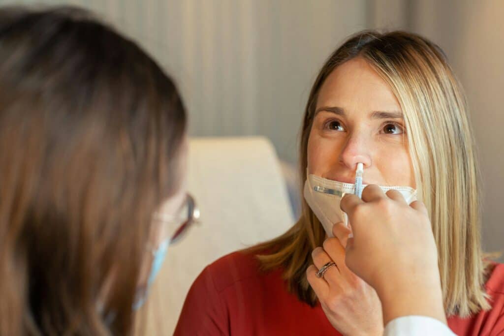 patient receiving nasal spray from a doctor